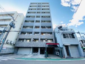 um edifício alto com um parque de estacionamento em frente em Apartment House Hakuyu Motomachi 1005 em Osaka
