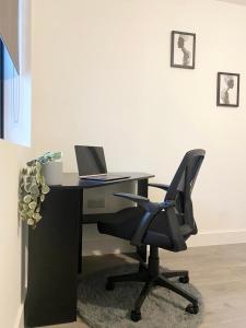 biurko z laptopem i krzesłem w pokoju w obiekcie Hemel Apartments- Tranquil Haven w mieście Hemel Hempstead