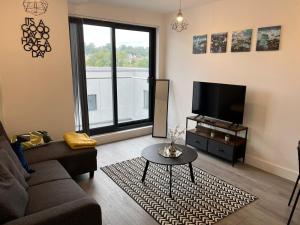 a living room with a couch and a tv at Hemel Apartments- Tranquil Haven in Hemel Hempstead
