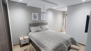 una camera con un letto e una parete bianca di Superbe Appartement Meublé a Mohammedia
