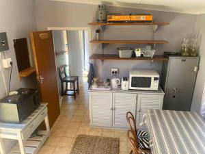 Una cocina con una encimera con un microondas encima. en Shades of grey, en Oudtshoorn