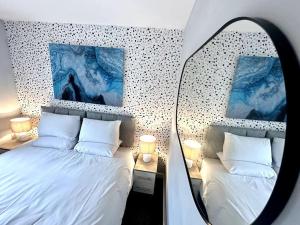 a mirror reflection of a bedroom with two beds at Newham House by Blue Skies Stays in Stockton-on-Tees