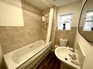 a bathroom with a tub and a sink and a toilet at Newham House by Blue Skies Stays in Stockton-on-Tees
