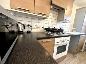 a kitchen with a black counter top and appliances at Newham House by Blue Skies Stays in Stockton-on-Tees