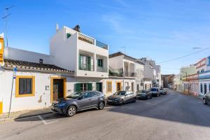 a row of cars parked on the side of a street at Casa Verde in Tavira