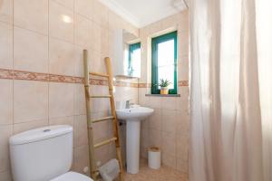 a bathroom with a toilet and a sink at Casa Verde in Tavira +40 photos