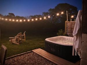 a hot tub in the yard at night with lights at Acorn Barn in Crediton