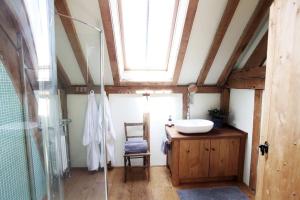 a bathroom with a sink and a glass shower at Acorn Barn in Crediton +11 photos