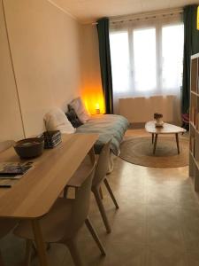 Una habitación con una mesa y una cama en una habitación en Grand studio avec petite vue mer, en Mers-les-Bains