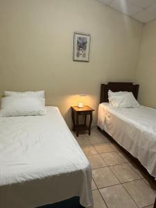 a bedroom with two beds and a table with a lamp at Casa de Campo en Salcoatitan in Salcoatitán