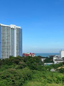 a view of two tall buildings and the ocean at Prautamnak Grand Apartments in Pattaya South