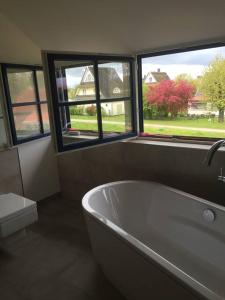 グロース・シュヴァンセにあるStilvolles Reetdachhaus Coastline an der Ostseeのバスルーム(バスタブ、トイレ、窓付)