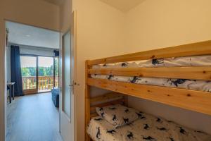 萊代塞爾的住宿－Chaleureux studio au pied des pistes - Le refuge，一间带两张双层床的卧室和一个阳台