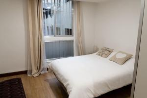 een wit bed in een kamer met een raam bij Casa Grande en Casco Histórico in Santander