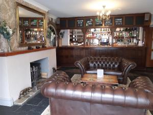a bar with two leather couches and a fireplace at East Ayton Lodge Hotel, Scarborough in Scarborough