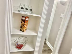 a white book shelf with a basket of food at Peaceful Apt Home FREE PKNG Private Balcony in Houston