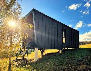 ein schwarzes Haus, das auf einem Feld steht in der Unterkunft NOIA Loft in Piatra Neamţ