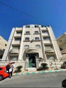 Yaso Roof & Apartments في عمّان: سيارة حمراء متوقفة أمام مبنى