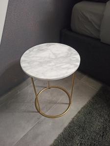 a white marble table with a gold frame next to a couch at Le Mirage in Chieti