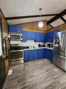 a kitchen with blue cabinets and stainless steel appliances at Pecosa home in Bushkill