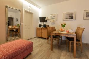 Cette chambre comprend une table, un lit et un miroir. dans l'établissement Ferienwohnung Muschelbank - Villa Sanssouci, à Binz