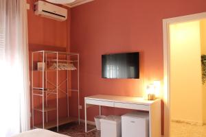 サレルノにあるCasa Hariのデスク、壁掛けテレビが備わる客室です。