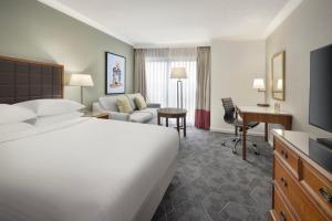 ウィンザーにあるDelta Hotels by Marriott Heathrow Windsorのベッドとデスクが備わるホテルルームです。