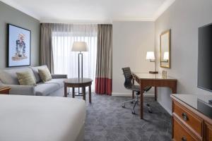 Habitación de hotel con sofá y escritorio en Delta Hotels by Marriott Heathrow Windsor, en Windsor