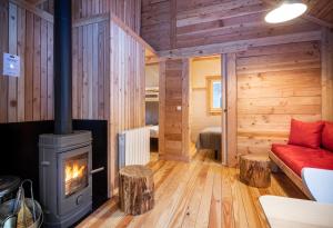 a living room with a wood stove in a log cabin at Huttopia La Clarée in Val-des-Prés