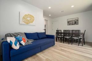 a living room with a blue couch and a dining room at Stylish 4BR Home near Disneyland wParking in Midway City