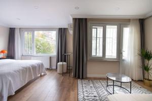a bedroom with a bed and a table and windows at Spacious & Trendy 3BR Urban Home w/ ACs in Istanbul