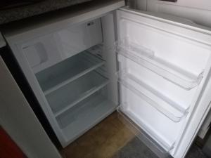 een lege koelkast met de deur open in een keuken bij Cowslip Corner Room with Sea View in Broad Haven