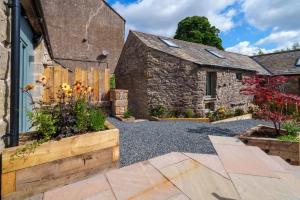 a stone house with a garden in front of it at Tan Apartment - Shap - Great for Walkers in Shap