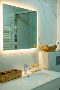 a bathroom sink with a mirror and a basket at Deluxe Swan Stone Castle Apartment in Budapest