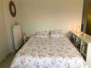 1 dormitorio con 1 cama con colcha de flores en Grand studio avec petite vue mer, en Mers-les-Bains