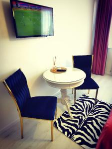 een kamer met een tafel en twee stoelen en een televisie bij Studio Alexandra in Galaţi