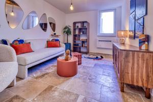 a living room with a couch and a table at Les Jasmins en Provence in L'Isle-sur-la-Sorgue