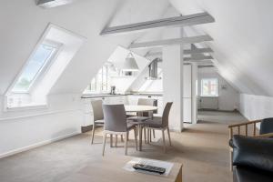 a dining room and kitchen with a table and chairs at Hotel Litorina Appartements in Løkken