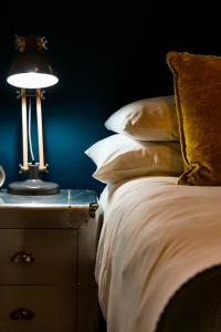 a bed with pillows and a lamp on a night stand at 16 On Antrim in Hermanus