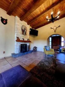 a living room with a stone fireplace and a ceiling at Casa de campo Santa Elena in Huasca de Ocampo