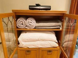 a wooden shelf with towels and a hair dryer on top at Stansted Lodge Plus long Stay Car Park in Elsenham