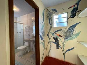 a bathroom with a shower with birds painted on the wall at Vila Amor - Charmosa e Central in Alto Paraíso de Goiás