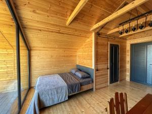 una camera da letto in una cabina di legno con un letto in esso di ARMBEE Honey Farm a Alaverdi