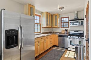 a kitchen with a stainless steel refrigerator and wooden cabinets at Private, Quiet 2BR in Central Culver City Parking in Los Angeles