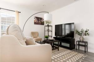 a living room with a white couch and a television at Centrally Located 2BR Home near LAX SoFi Stadium in Inglewood