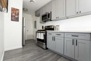 a kitchen with white cabinets and a stove top oven at Centrally Located 2BR Home near LAX SoFi Stadium in Inglewood