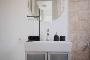 a bathroom with a white sink and a mirror at Centrally Located 2BR Home near LAX SoFi Stadium in Inglewood