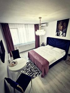 een slaapkamer met een bed, een tafel en een stoel bij Studio Alexandra in Galaţi