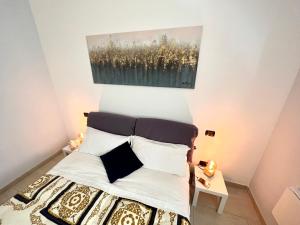 1 dormitorio con 1 cama con una pintura en la pared en Belvedere in Costa - Lake View, en Bellano