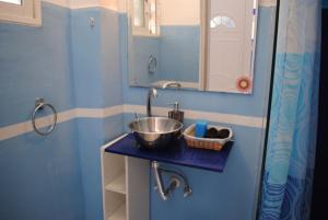 een kleine badkamer met een wastafel en een spiegel bij Karmik Concept Apartments in Afantou